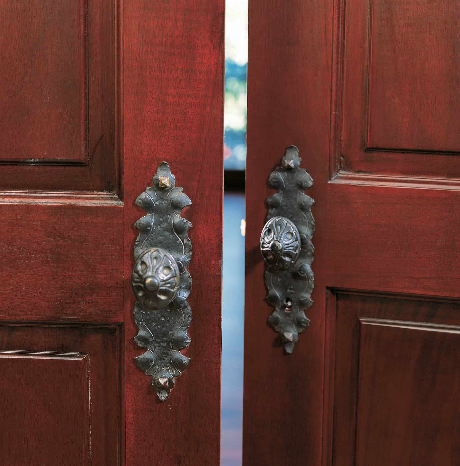 Custom brass door handle on dark mahogany