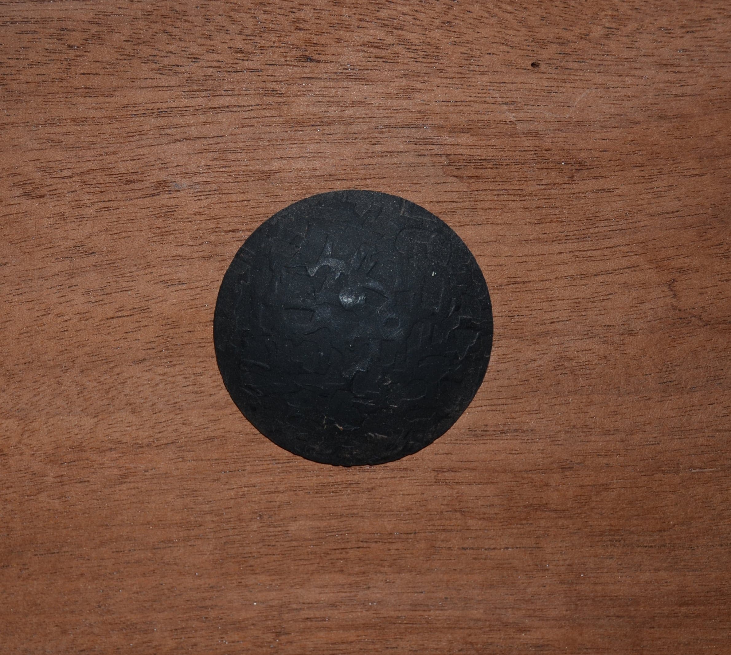 Hand-hammered decorative round nail on mahogany