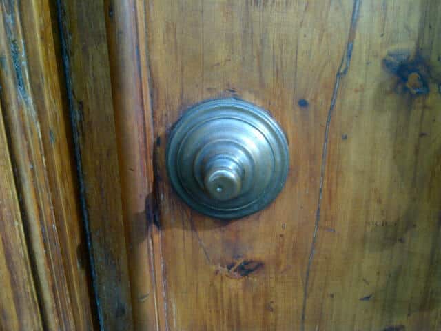 Antique brass tiered rosette on paneled mahogany