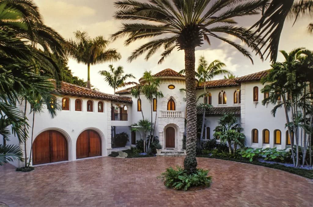 Mediterranean estate with mahogany garage doors, entry, and arched windows
