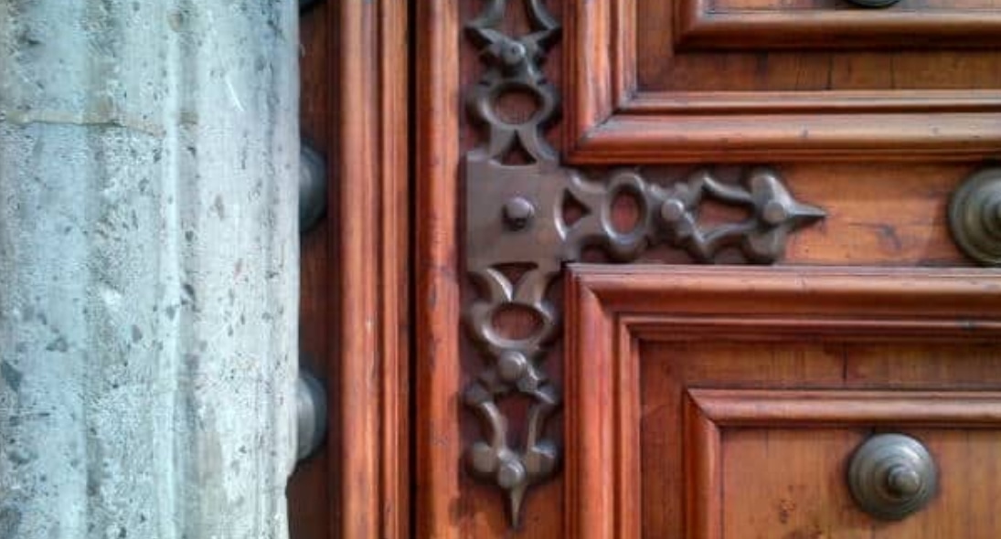 Ornate mahogany door with decorative metal hardware